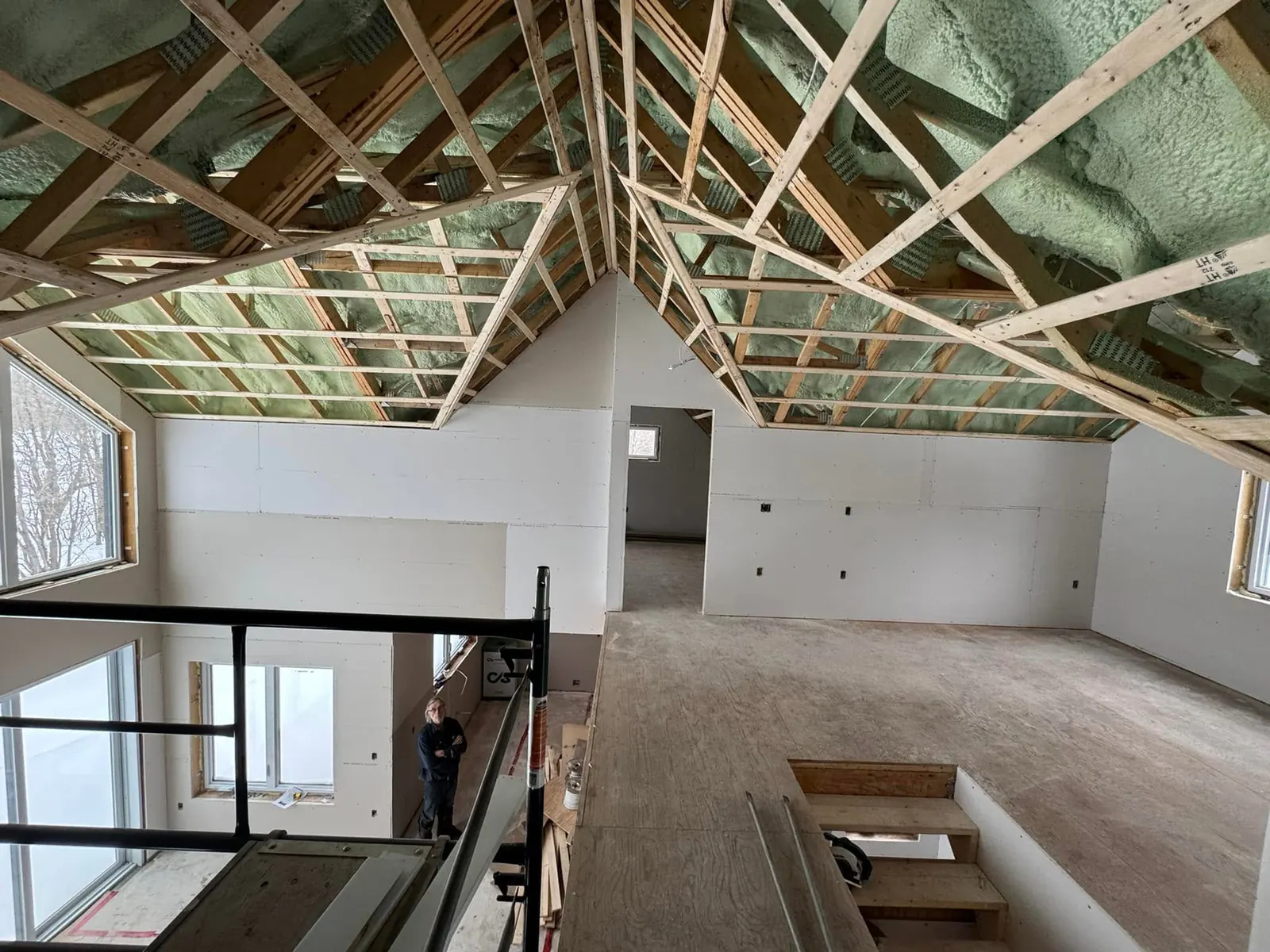 Mezzanine et murs en gypse sous un plafond cathédrale dans une maison neuve